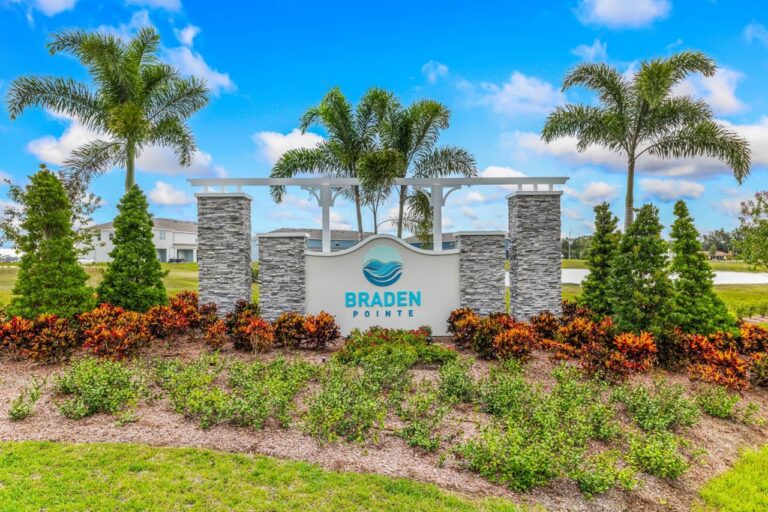 Entrance monument sign with palms and pergola at Braden Pointe, Bradenton, Florida