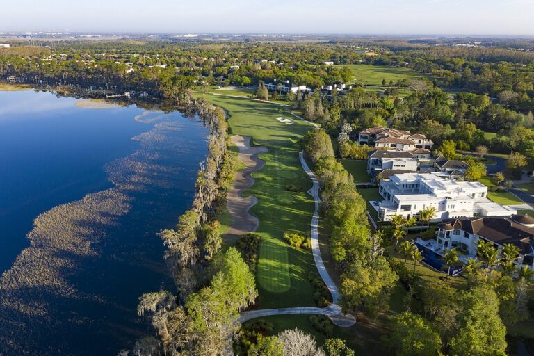 Aerial view of a Florida golf community with fairways along a lake and homes beside the course