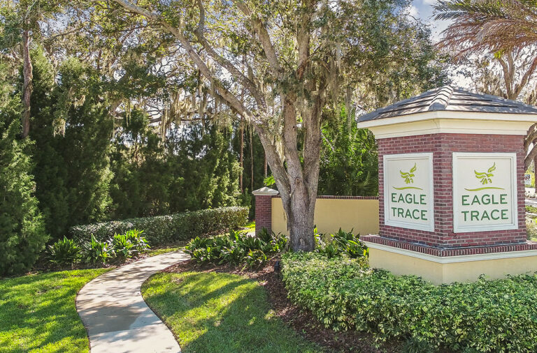 Brick entrance monument sign under live oaks at Eagle Trace, Bradenton, Florida