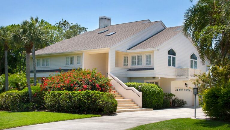 Raised coastal home with tropical landscaping at Tidy Island, Bradenton, Florida